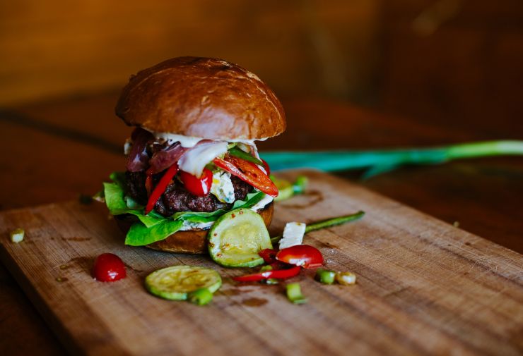 Hamburger topped with heaping vegetables